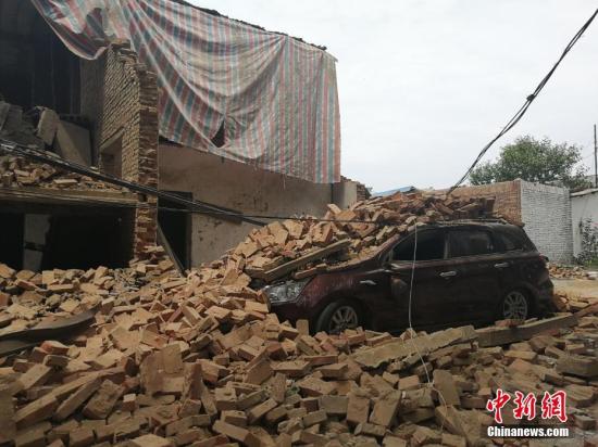 图为义马爆炸造成的坍塌将一辆汽车掩埋。 刘鹏 摄 点击进入下一页